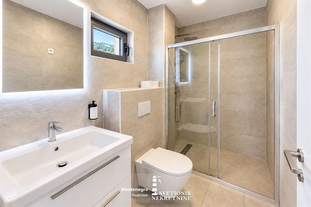Moderne kupatilo sa tuš kabinom, umivaonikom i wc šoljom.