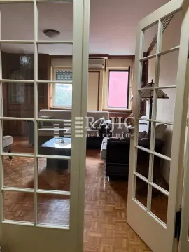 View through double glass doors into a furnished living room. - image 8