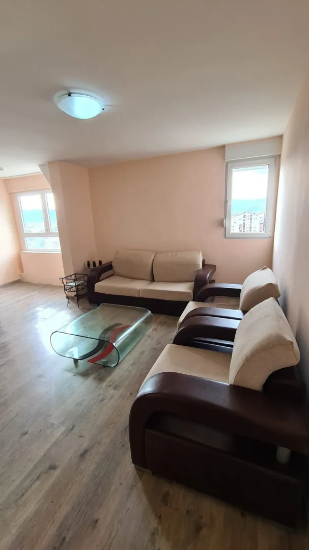 Living room with sofa set and glass coffee table.