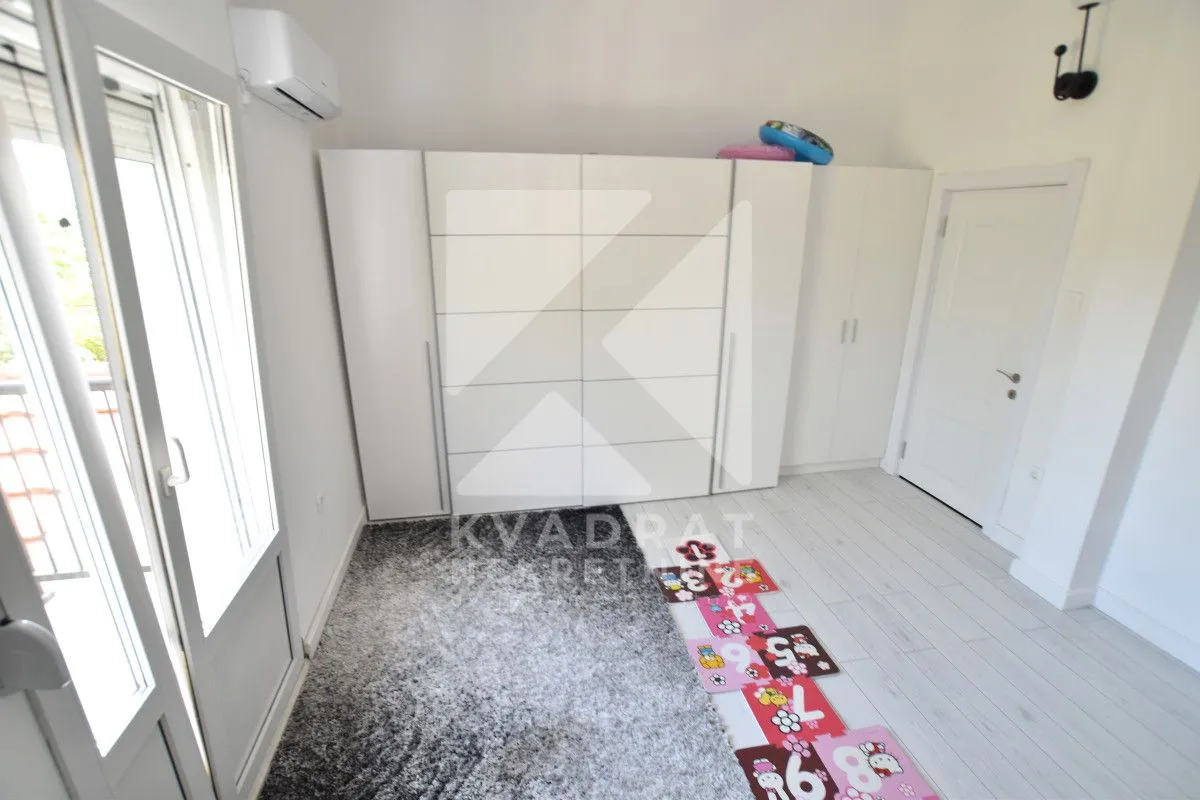 Bedroom with a white wardrobe, a rug, and access to the terrace.
