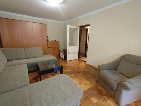 Dnevna soba sa garniturom, foteljom i drvenim ormarima. - image 2
