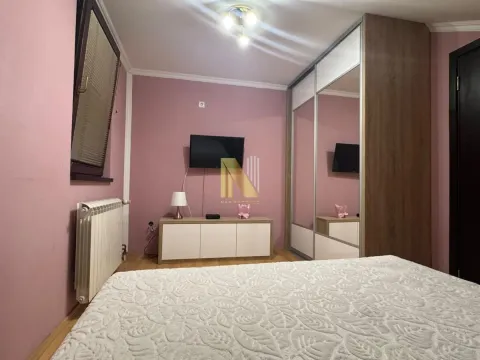 Spavaća soba sa krevetom, velikim garderoberom sa ogledalima i televizorom. - image 13