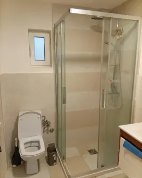 Small bathroom with a walk-in shower and toilet. - image 7