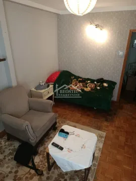 Living room with an armchair, a bed, and a coffee table. - image 3