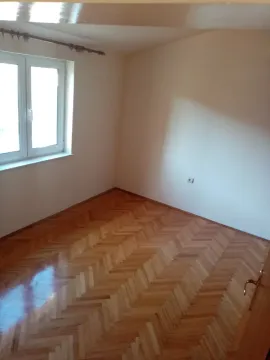 An empty room with parquet flooring and a window. - image 17