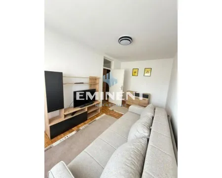 Living room with a sofa bed, TV, and wooden furniture. - image 2