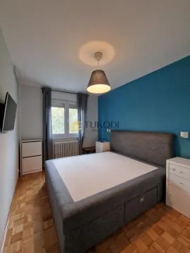 Furnished bedroom with a large double bed and a blue accent wall. - image 13