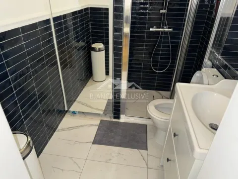 Moderno opremljeno kupatilo sa tuš kabinom i crnim pločicama. - image 14