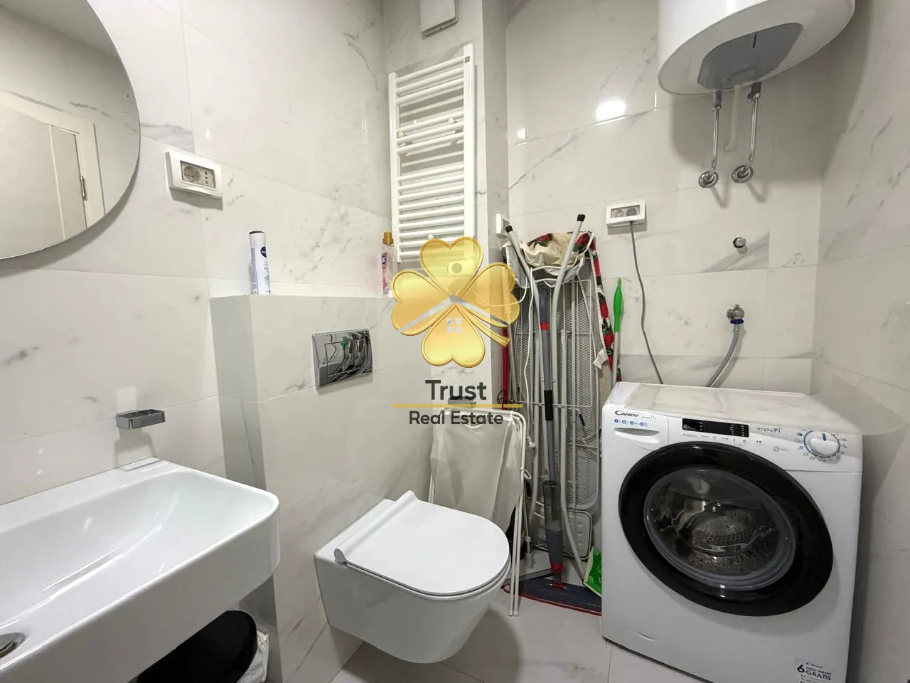 Small bathroom with a sink, toilet, and washing machine.