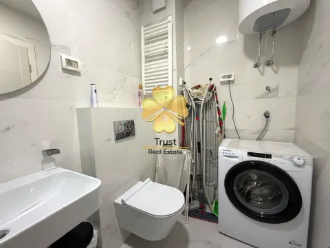 Small bathroom with a sink, toilet, and washing machine. - image 11