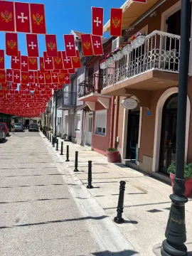 Street with traditional houses and Montenegrin flags. - image 5