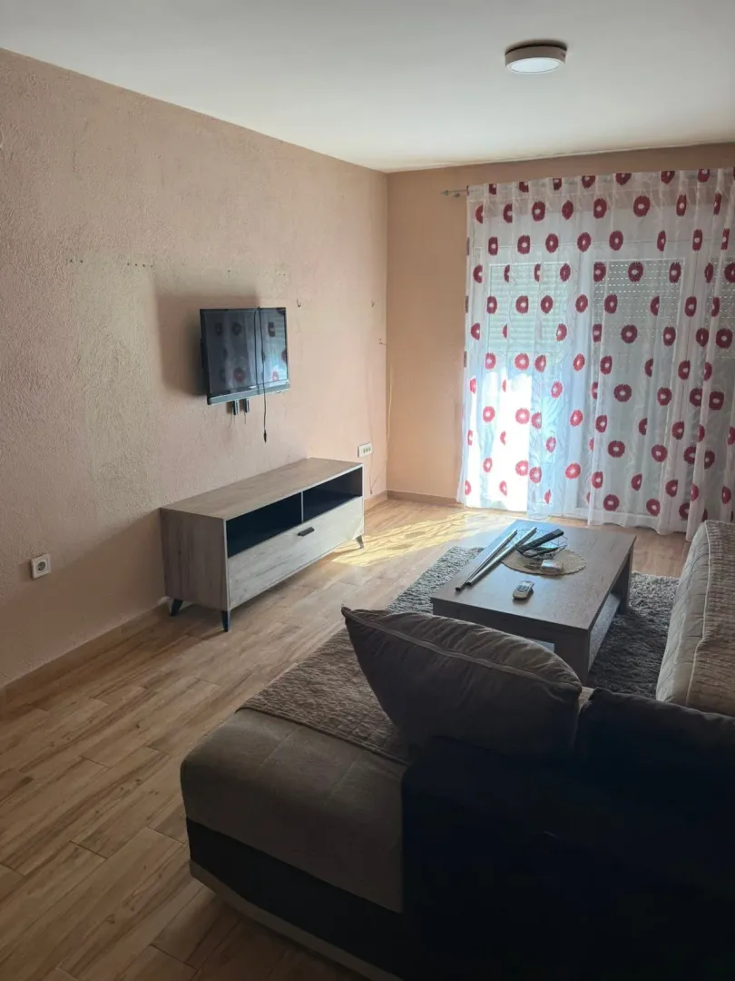 Living room with a sofa, TV, and coffee table.