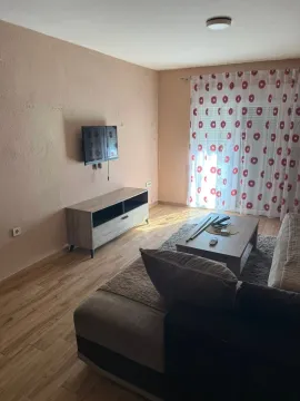 Living room with a sofa, TV, and coffee table. - image 4