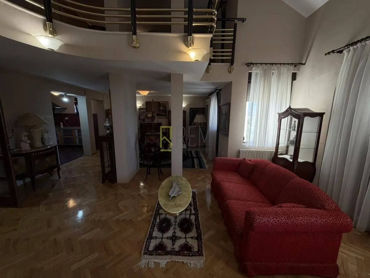 Spacious living room with gallery and parquet flooring.