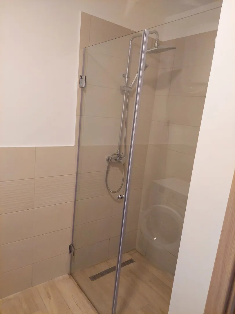 Modern bathroom with a shower cabin and glass partition.