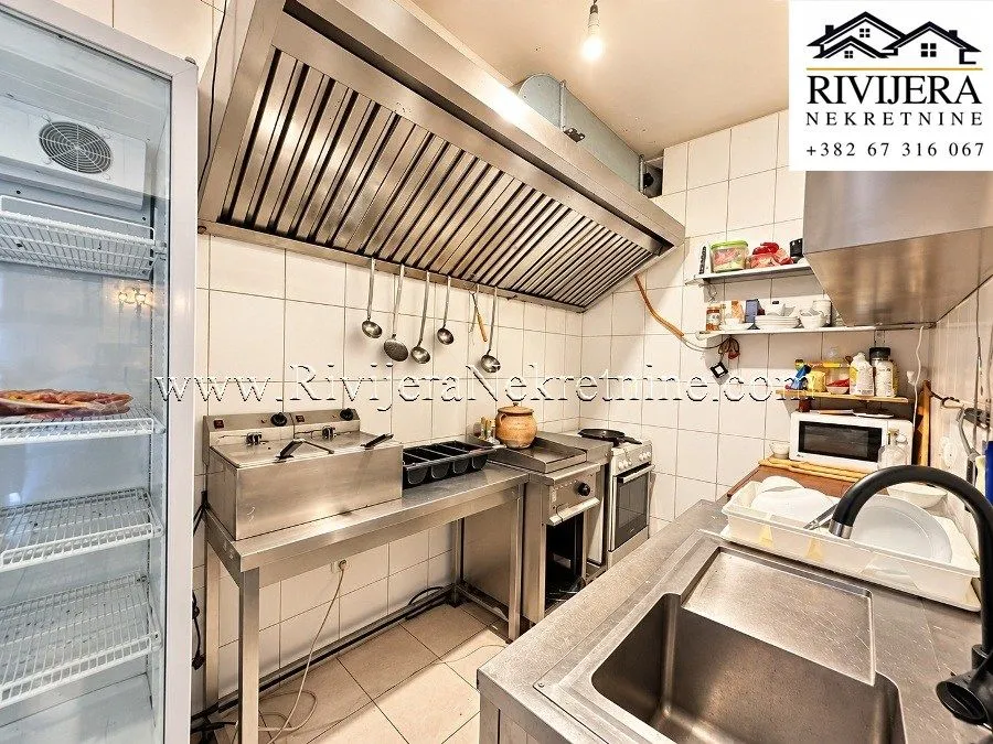 Commercial kitchen with professional stainless steel equipment and appliances.