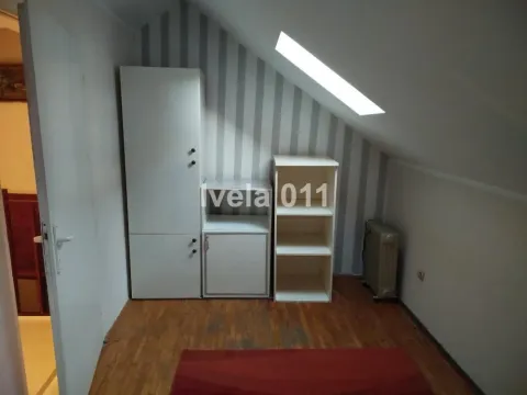 Potkrovlje sa kosim plafonom, krovnim prozorom i belim ormarima. - image 7