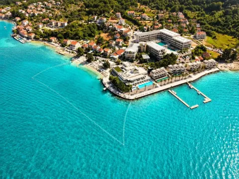 Pogled iz vazduha na primorsko naselje sa plažom i hotelom pored tirkiznog mora. - image 19