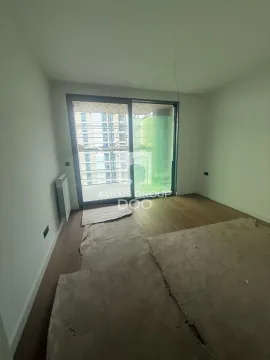 Empty unfinished room with wooden flooring and balcony doors. - image 5