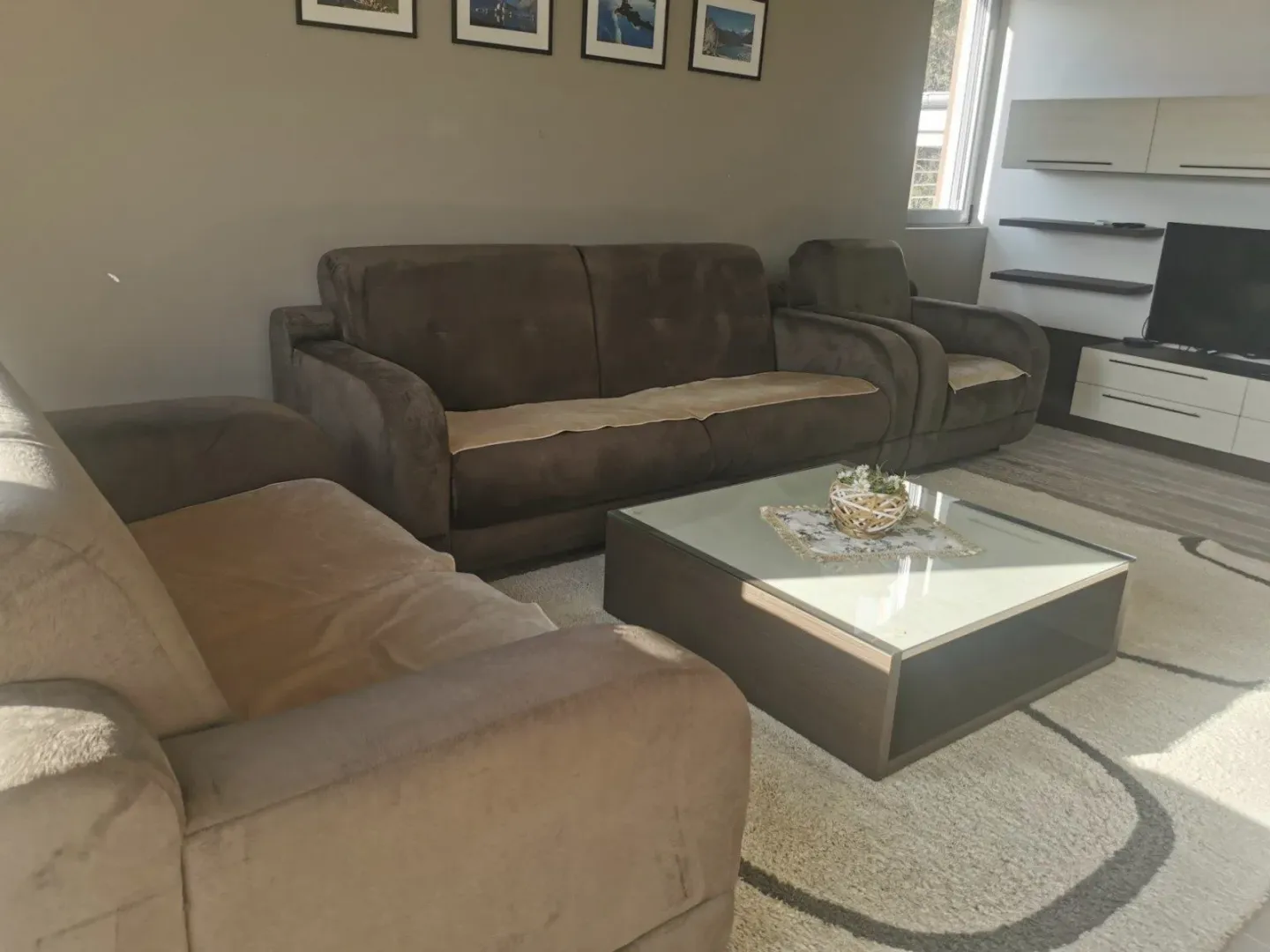 Living room with sofa set, coffee table, and TV.