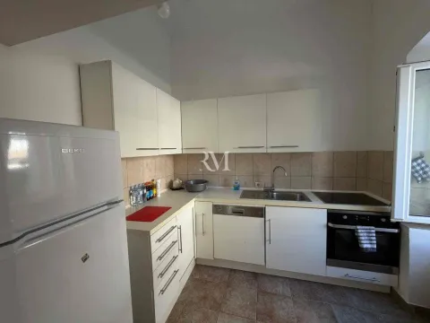 Smaller white kitchen with a refrigerator and built-in appliances. - image 7