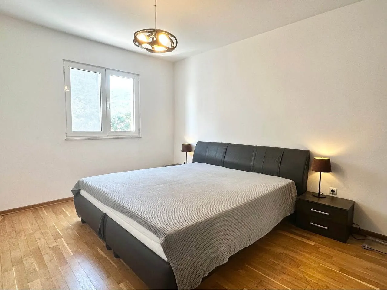 Bedroom with a double bed, bedside tables and a window.