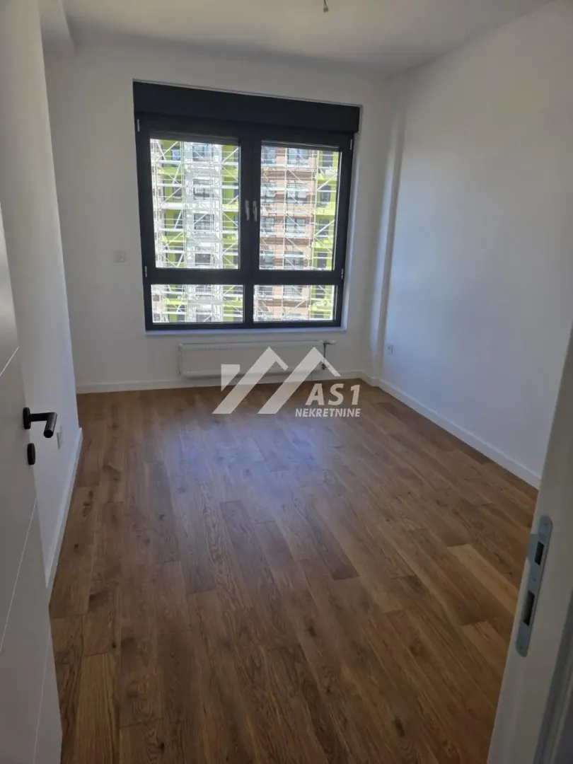 Empty room with hardwood floors and a window.