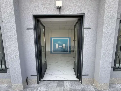 Entrance to a commercial space with glass doors and a paved sidewalk in front. - image 4