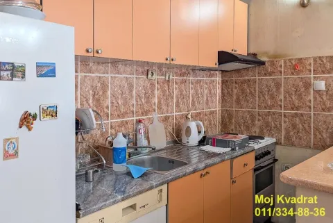 Manja kuhinja sa drvenim elementima, sudoperom i šporetom. - image 5