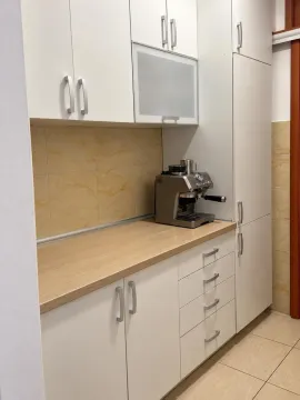 Bijeli kuhinjski elementi sa radnom površinom u boji drveta i aparatom za kafu. - image 4