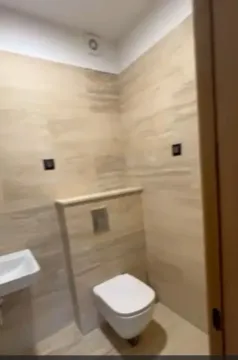 Moderno kupatilo sa bež pločicama i visećom wc šoljom. - image 8