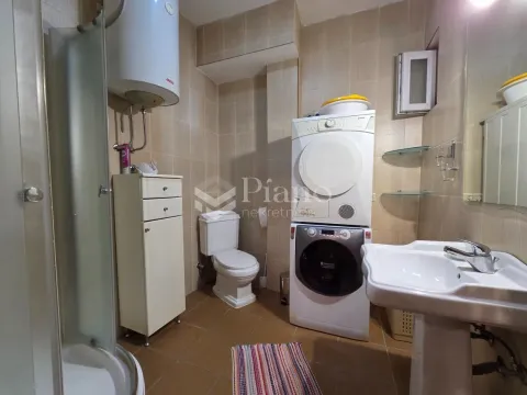 Bathroom equipped with a shower cabin, sink, toilet, and washing and drying machines. - image 8