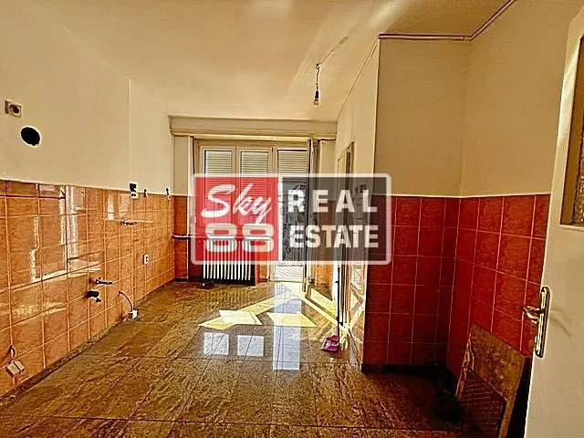 Empty kitchen with ceramic tiles on the walls and floor.