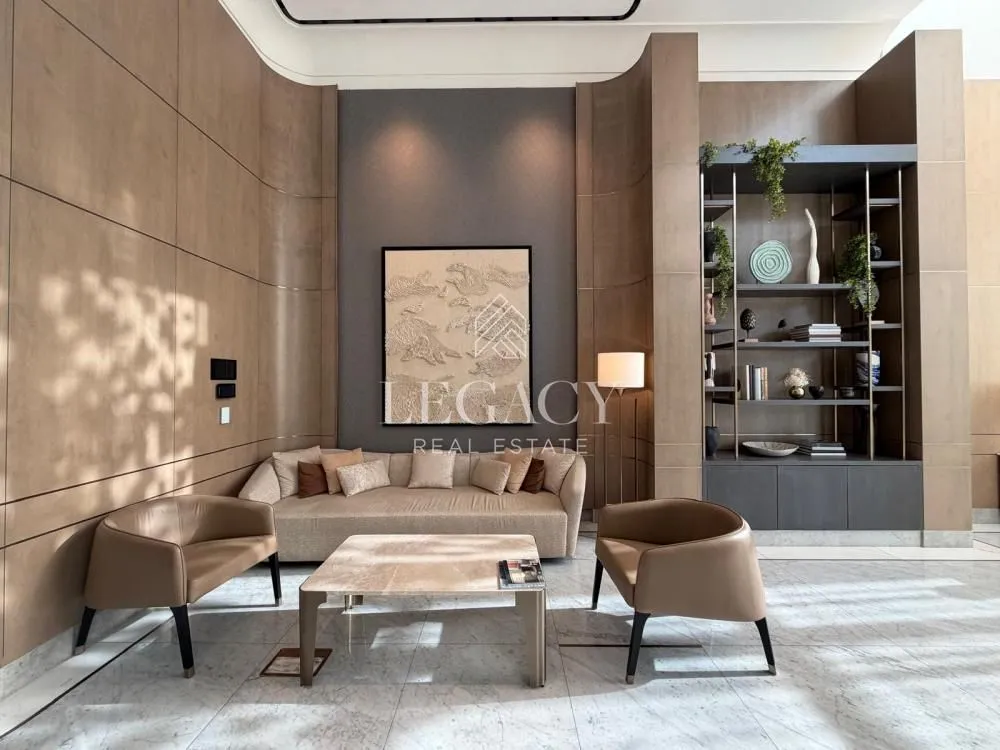 Spacious living room with a sofa, armchairs, coffee table, and decorative wall panels.