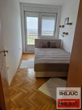 Nameštena spavaća soba sa bračnim krevetom i izlazom na terasu. - image 4