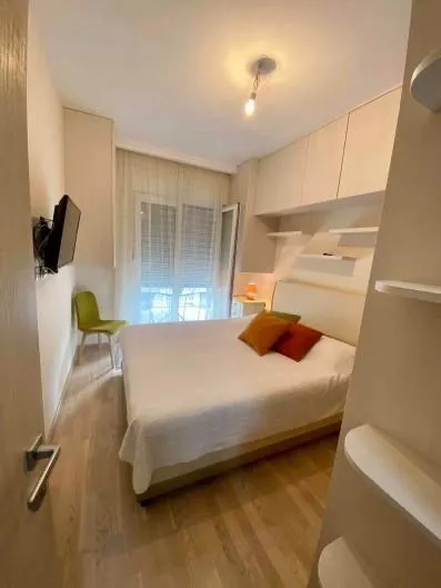 Small bedroom with a double bed, built-in wardrobes, and access to the terrace.