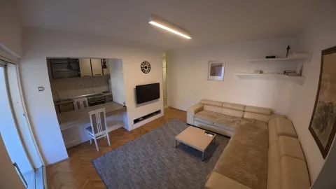 Spacious living room with a sectional sofa and a view of the kitchen. - image 11