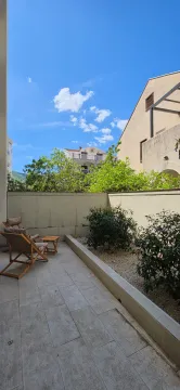 Popločano dvorište sa ležaljkama i uređenim zelenilom. - image 10