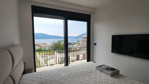 Bedroom with a double bed and a sea view through the balcony doors. - image 10