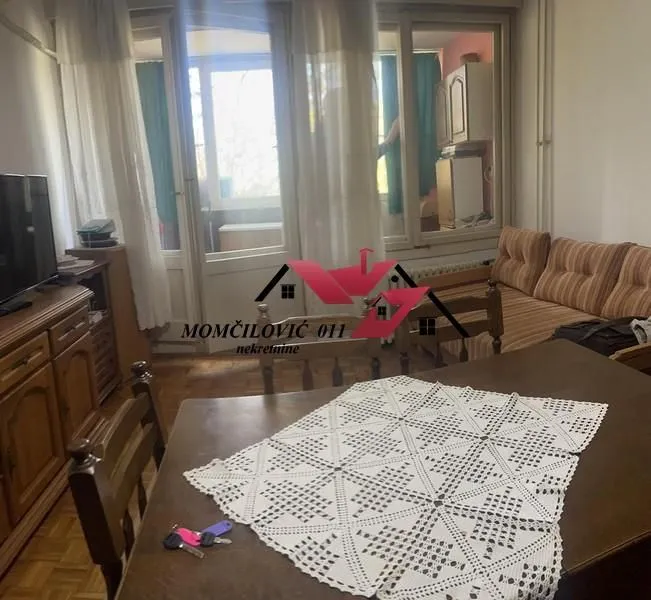 Dnevna soba sa trpezarijskim stolom, garniturom i izlazom na terasu.