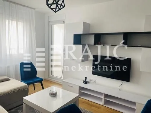 Living room with furniture, television and balcony access.
