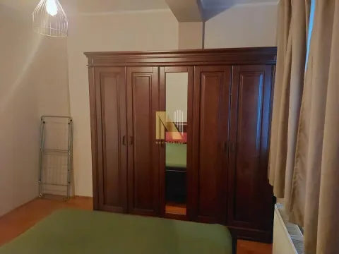 Nameštena spavaća soba sa velikim drvenim ormanom i krevetom. - image 7