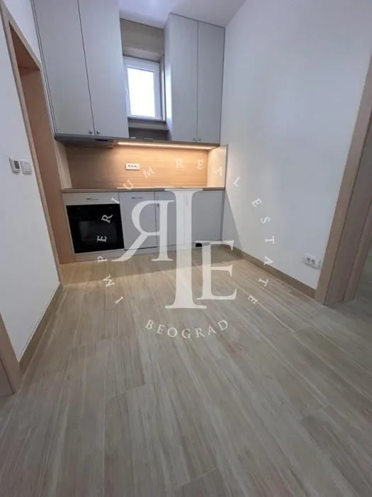 Small kitchen with built-in cabinetry and wooden flooring.