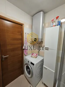 Manje kupatilo sa veš mašinom, bojlerom i bijelim ormarićem. - image 2