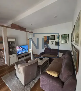 Namještena dnevna soba sa garniturom, foteljom, TV-om i slikama na zidu. - image 2