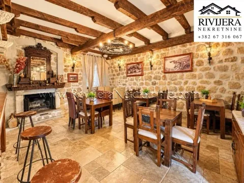 Rustic living room with stone walls, wooden beams, and a fireplace. - image 10