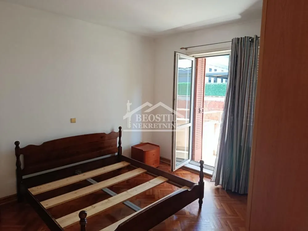 Bedroom with a wooden bed and access to the terrace.