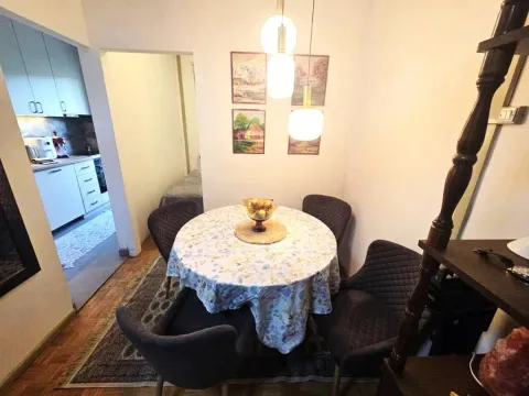 Trpezarija sa okruglim stolom i stolicama, uz prolaz ka kuhinji. - image 4