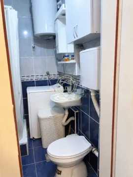 Manje kupatilo sa plavim pločicama, umivaonikom, WC šoljom, mašinom za veš i tuš kabinom. - image 14