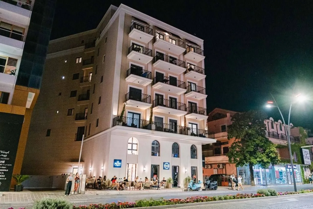 Exterior view of a multi-story residential building at night with ground floor commercial space.